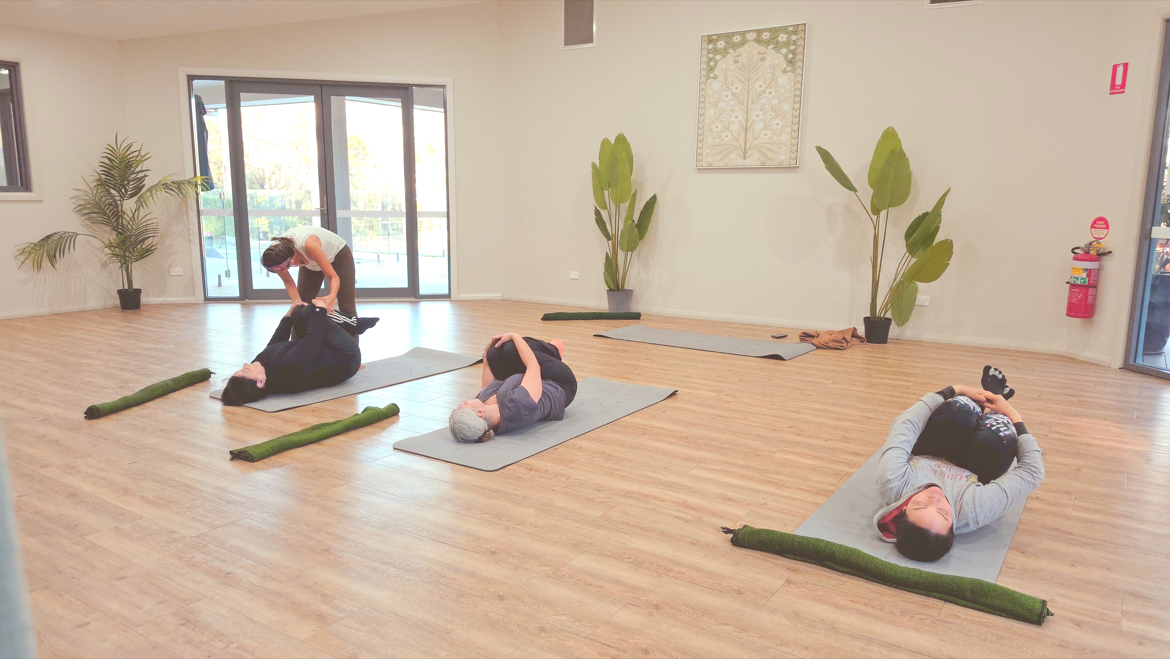People practising guided breath and movement in a bright room overlooking the city